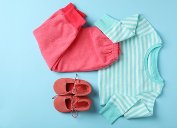 Photo of Flat lay composition with cute child clothes and shoes on color background