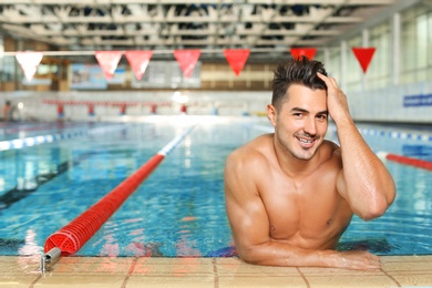 Young athletic man in swimming pool indoors