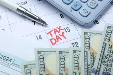 Photo of Calendar with date reminder about tax day, money, pen and calculator, closeup