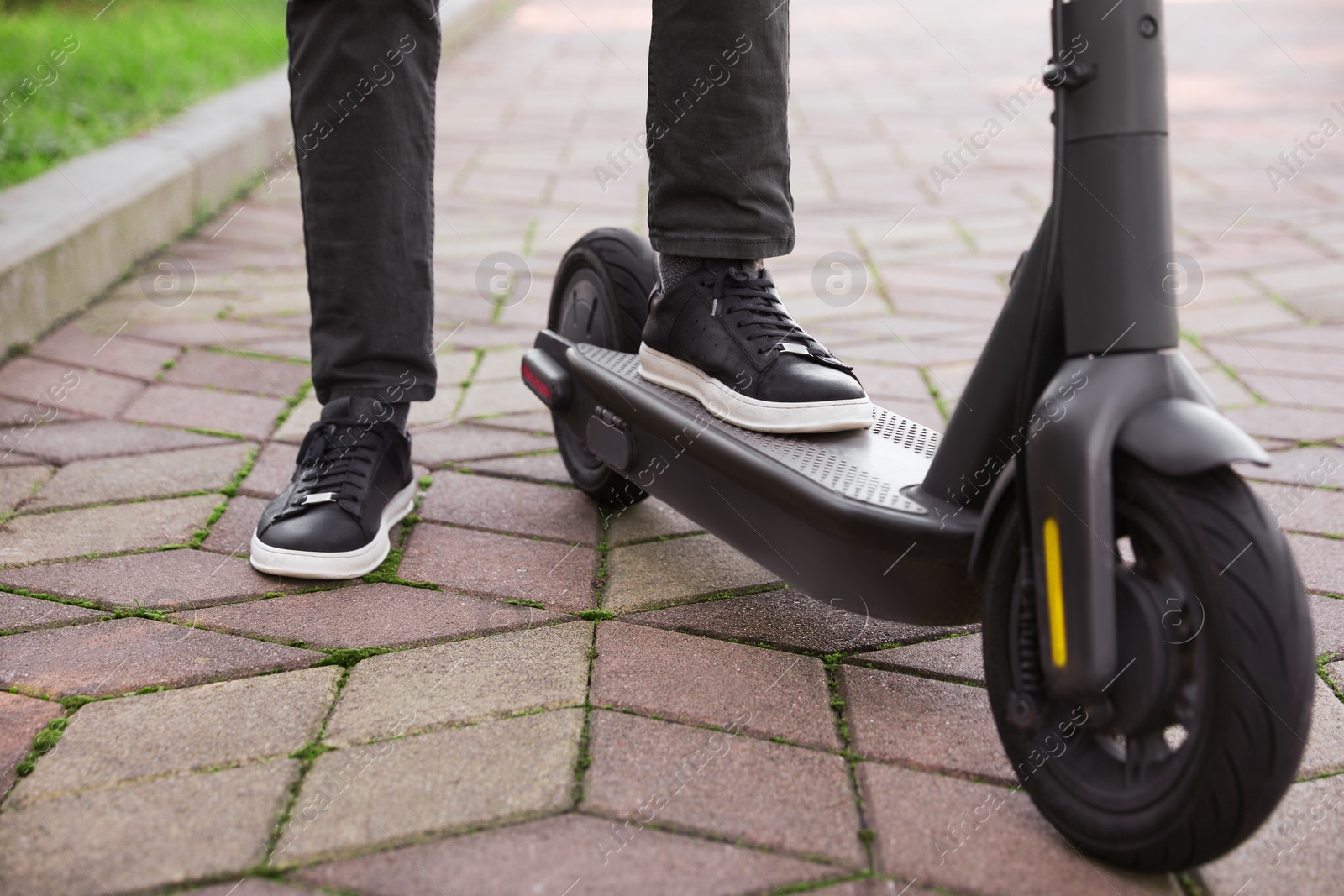 Photo of Man riding modern electric scooter in park, closeup