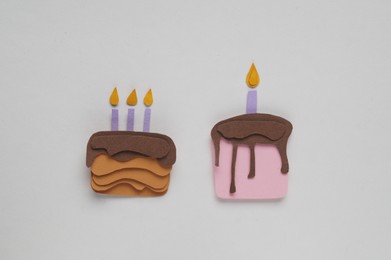 Different birthday cakes on white background, flat lay