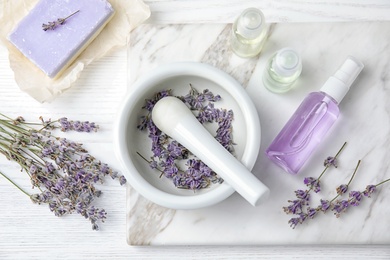 Flat lay composition with lavender flowers and natural cosmetic products on wooden background