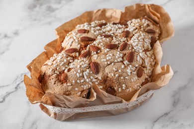 Photo of Delicious Italian Easter dove cake (Colomba di Pasqua) on white marble table, closeup