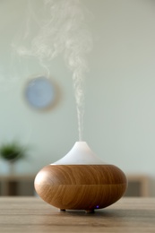 Photo of Modern aroma lamp on table in room