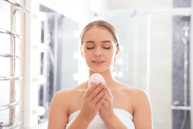 Photo of Young woman with soap bar in bathroom
