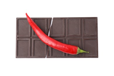 Photo of Dark chocolate bar with red hot chili pepper isolated on white, top view