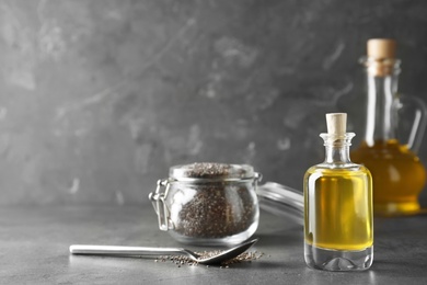 Photo of Composition with chia oil and seeds on grey table, space for text