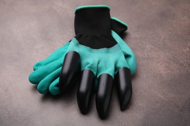 Photo of Pair of claw gardening gloves on brown textured table