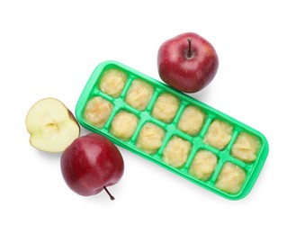 Photo of Apple puree in ice cube tray and fresh apple fruits isolated on white, top view. Ready for freezing