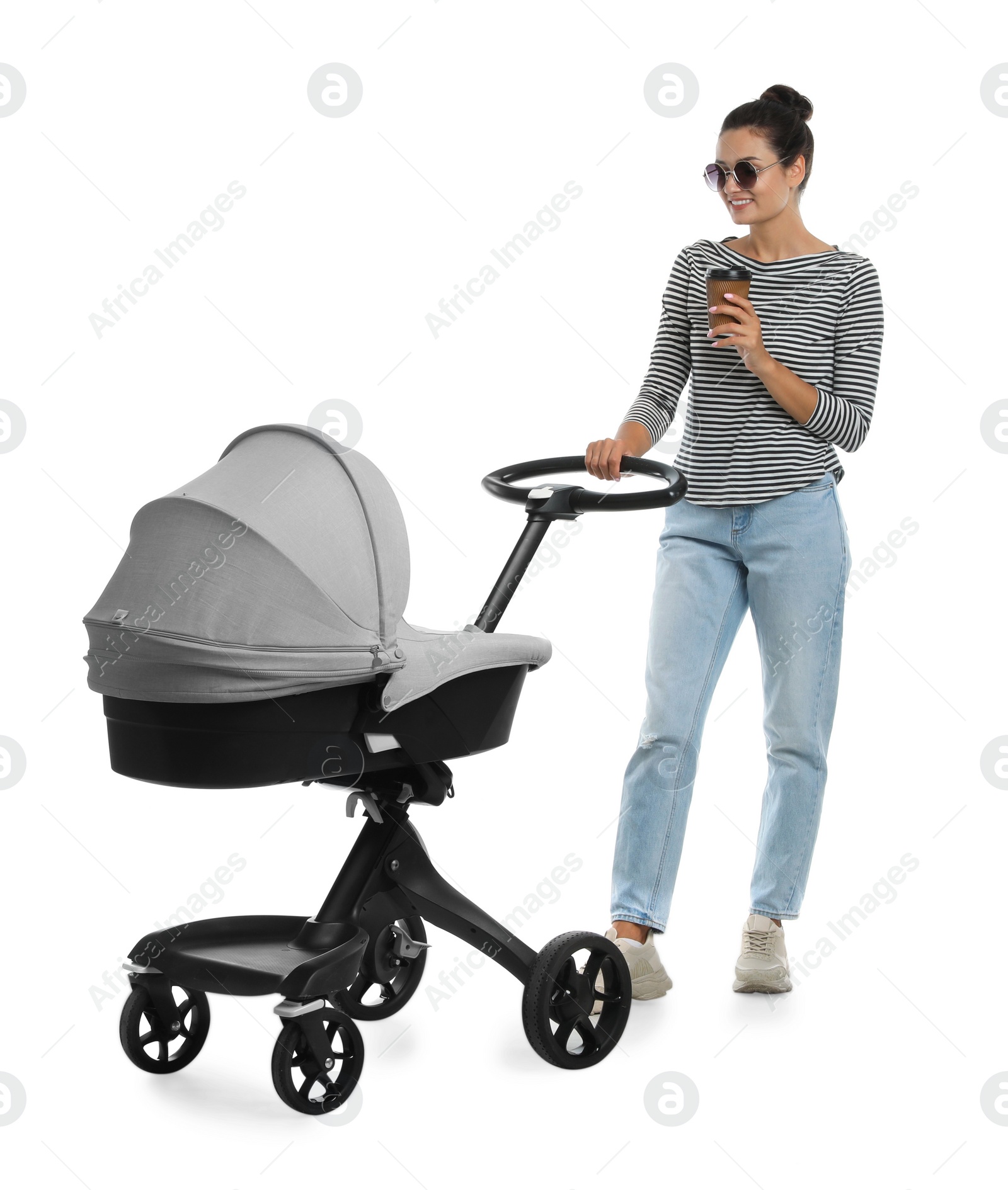 Photo of Happy young woman with cup of drink and baby stroller on white background