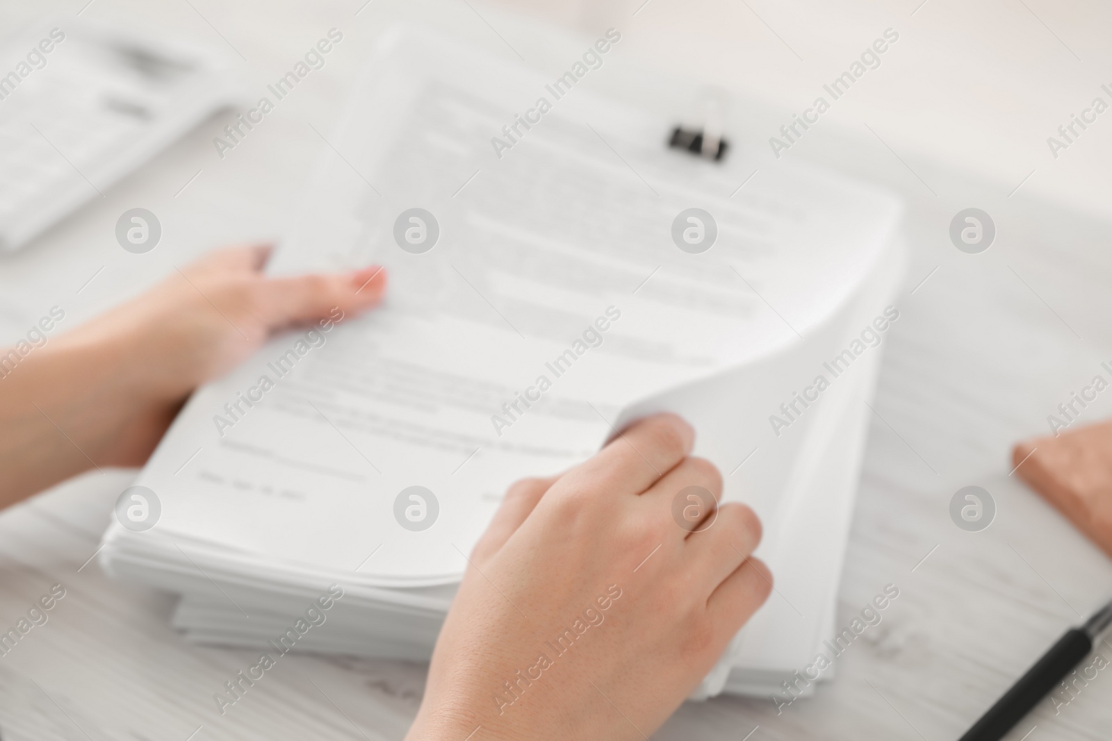 Photo of Woman reading documents at white table in office, closeup. Space for text