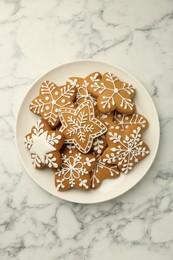 Photo of Tasty star shaped Christmas cookies with icing on white marble table, top view