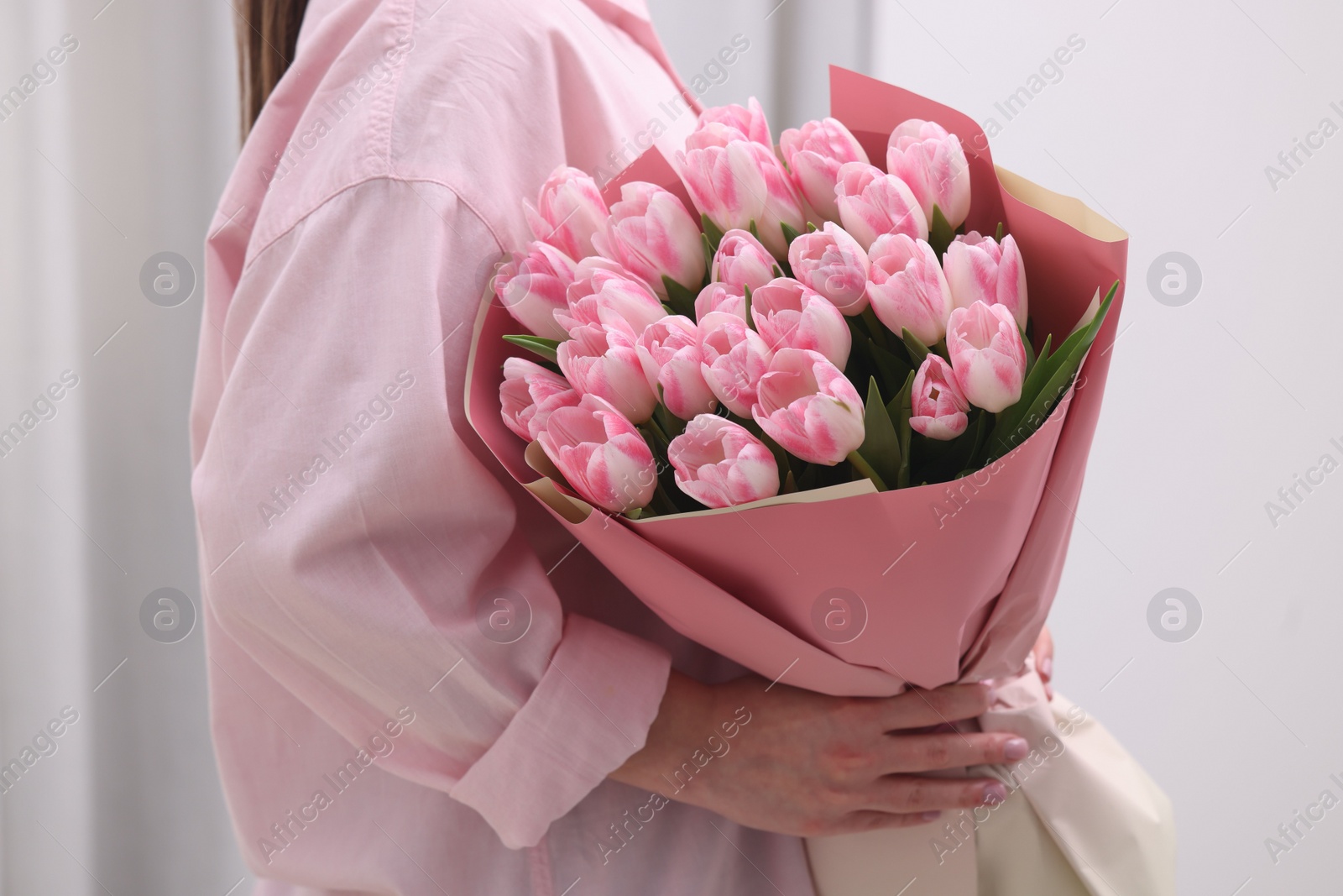 Photo of Woman with bouquet of beautiful fresh tulips on blurred background, closeup