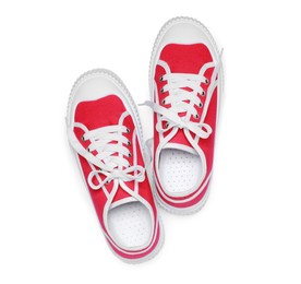 Photo of Pair of red classic old school sneakers isolated on white, top view