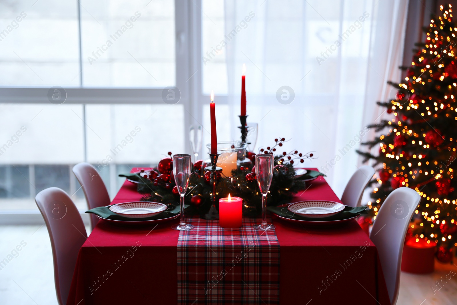 Photo of Stylish kitchen interior with festive table and decorated Christmas tree