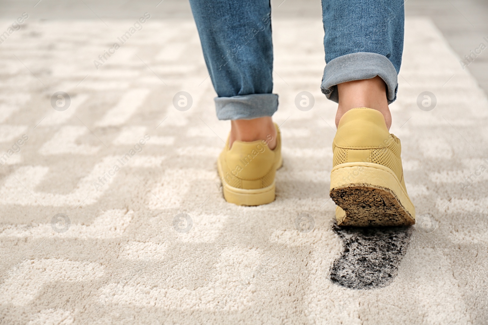 Photo of Person in dirty shoes leaving muddy footprints on carpet