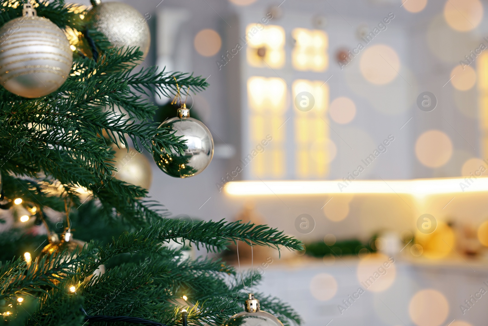 Photo of Closeup view of beautiful decorated Christmas tree in kitchen. Space for text