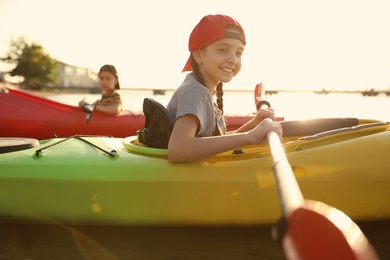 Little children kayaking on river. Summer camp activity