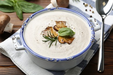 Photo of Delicious homemade mushroom soup served on wooden table, closeup