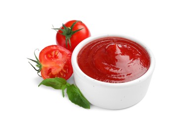 Photo of Tasty ketchup in bowl, basil and fresh tomatoes isolated on white