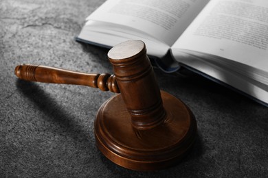 Law concept. Gavel and book on grey textured table, closeup