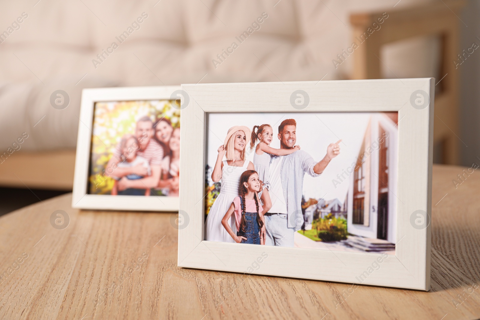 Photo of Pleasant memories. Frames with family photos on wooden table indoors, selective focus