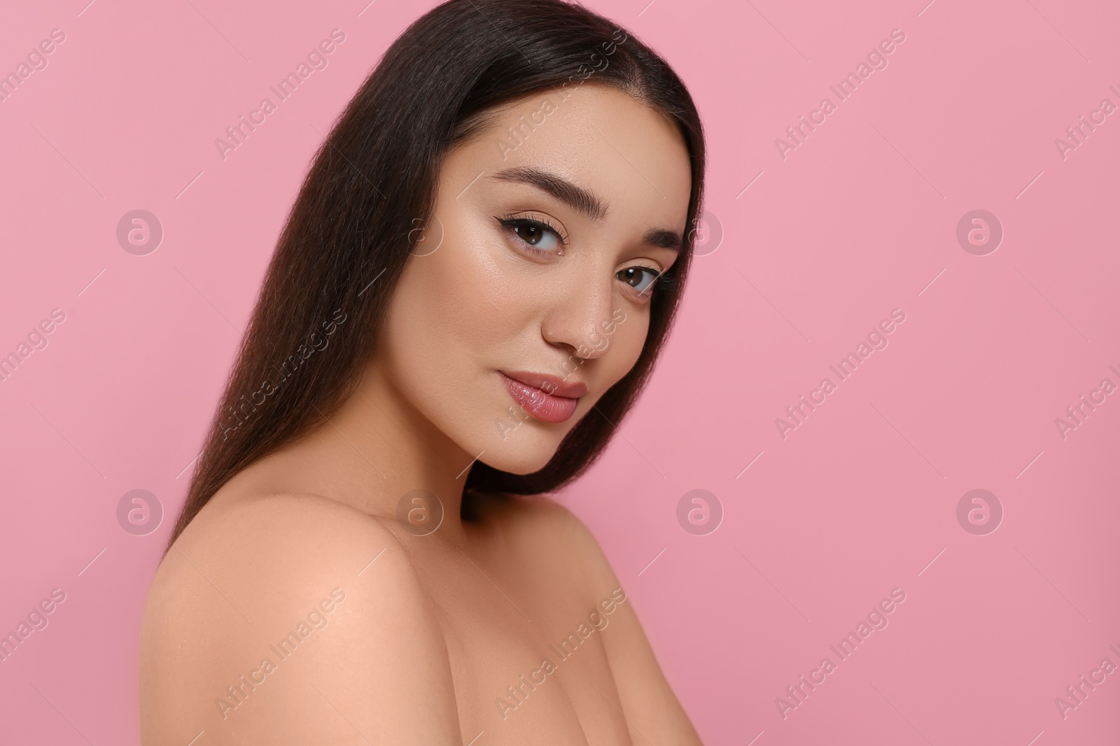 Photo of Portrait of beautiful young woman with elegant makeup on pink background. Space for text