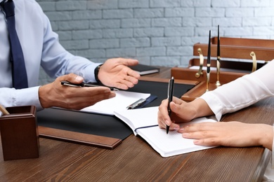 Photo of Male lawyer with client at table in office