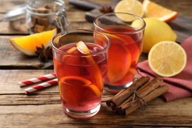 Photo of Aromatic punch drink and ingredients on wooden table