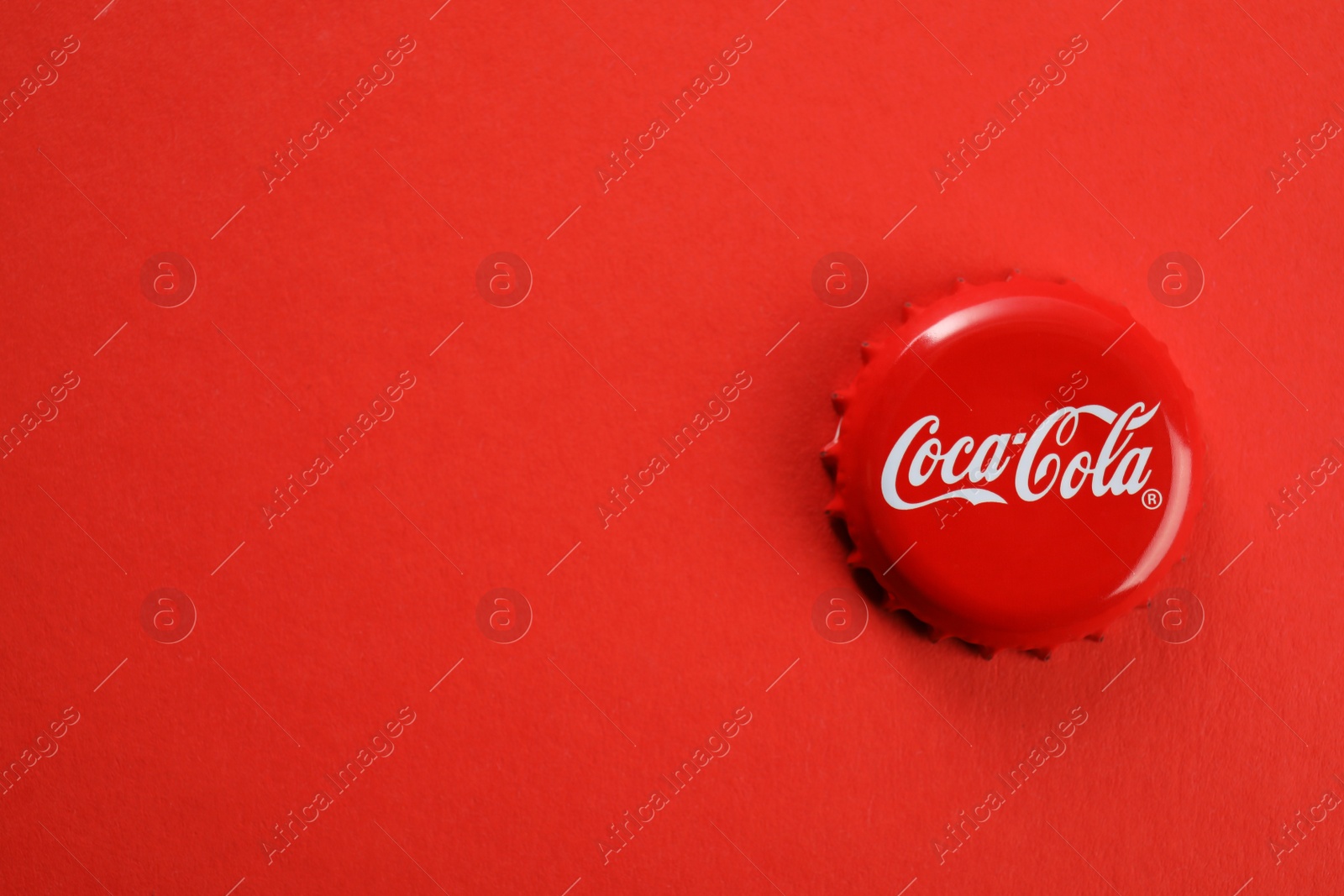 Photo of MYKOLAIV, UKRAINE - NOVEMBER 15, 2018: Coca Cola lid on color background, top view. Space for text