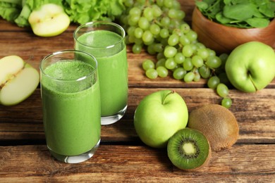 Green smoothie in glasses and fresh ingredients on wooden table