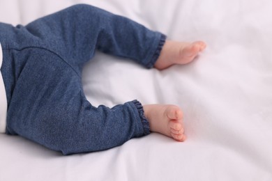 Newborn baby lying on white blanket, closeup