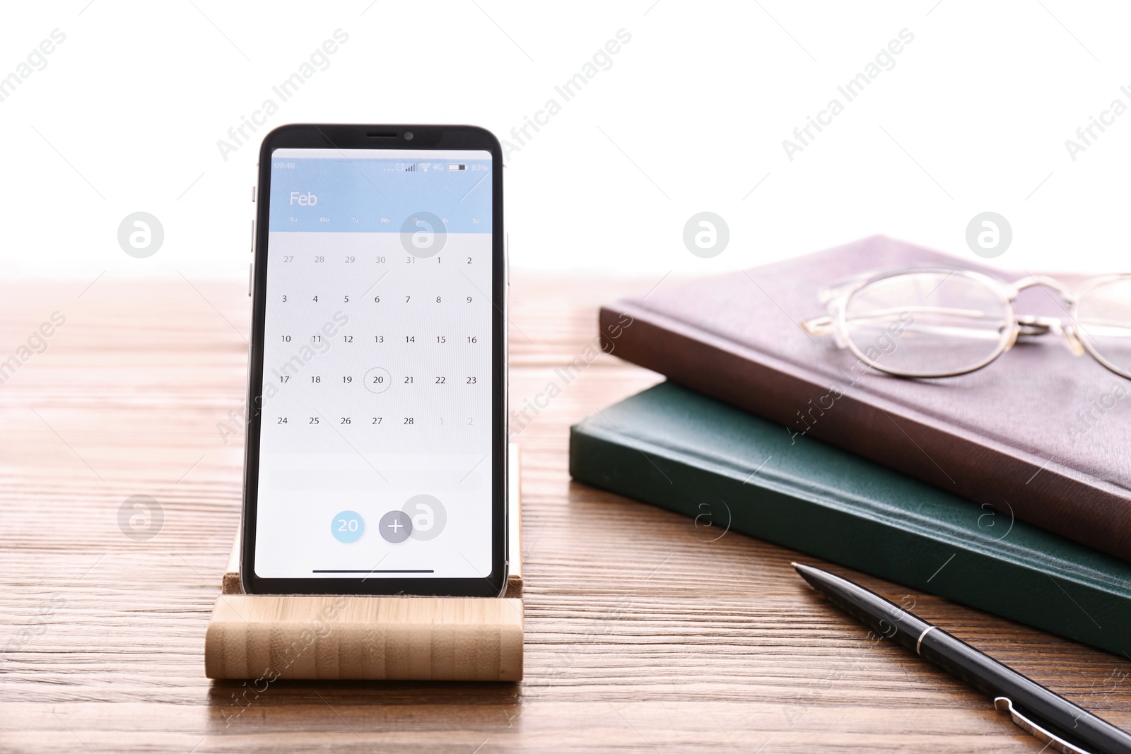 Photo of Smartphone with calendar app on wooden table