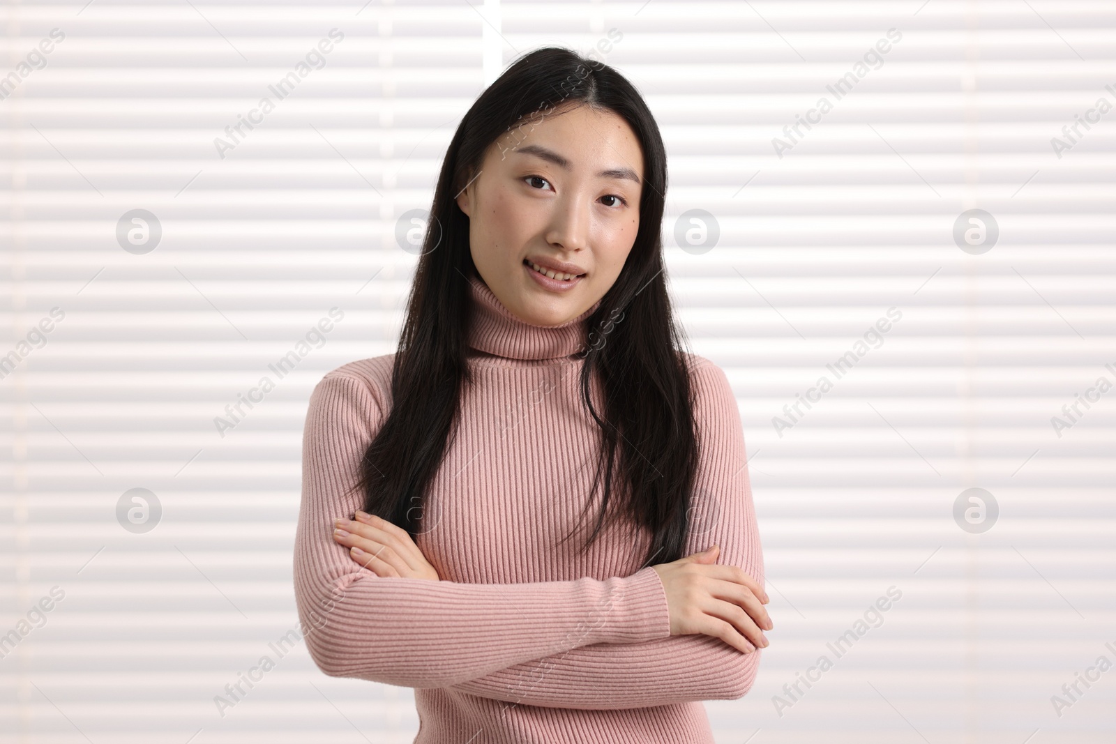 Photo of Portrait of smiling businesswoman with crossed arms in office