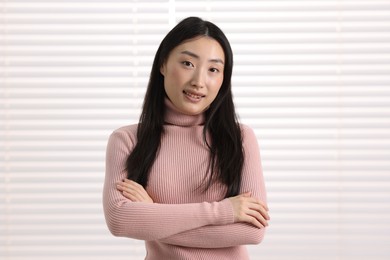 Portrait of smiling businesswoman with crossed arms in office