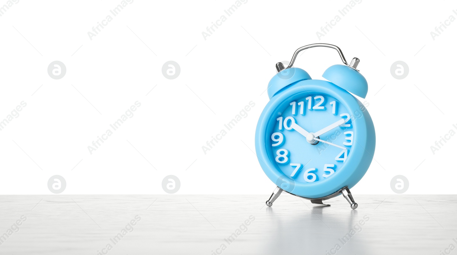 Photo of Alarm clock on table against white background. Time concept