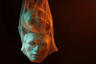 Net bag with plastic face masks on black background, space for text. Theatrical performance