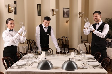 Group of people learning how to set table during professional butler courses