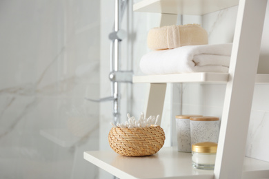 Photo of Shelving unit with toiletries in bathroom interior