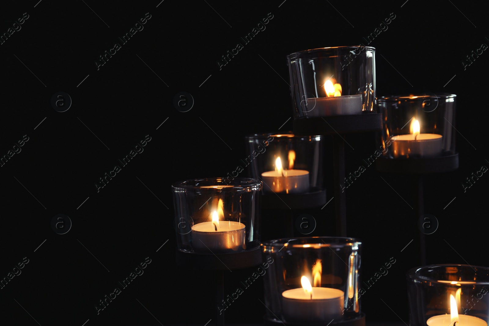 Photo of Burning candles on dark background. Funeral symbol