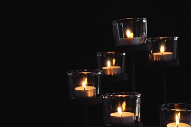 Photo of Burning candles on dark background. Funeral symbol