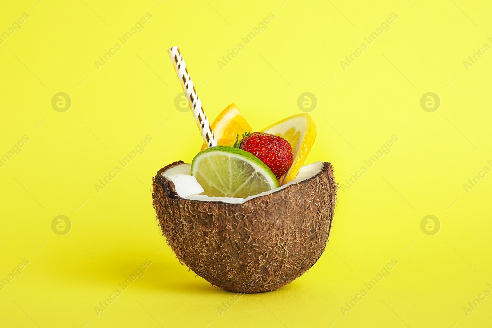 Photo of Summer refreshing cocktail in coconut on color background