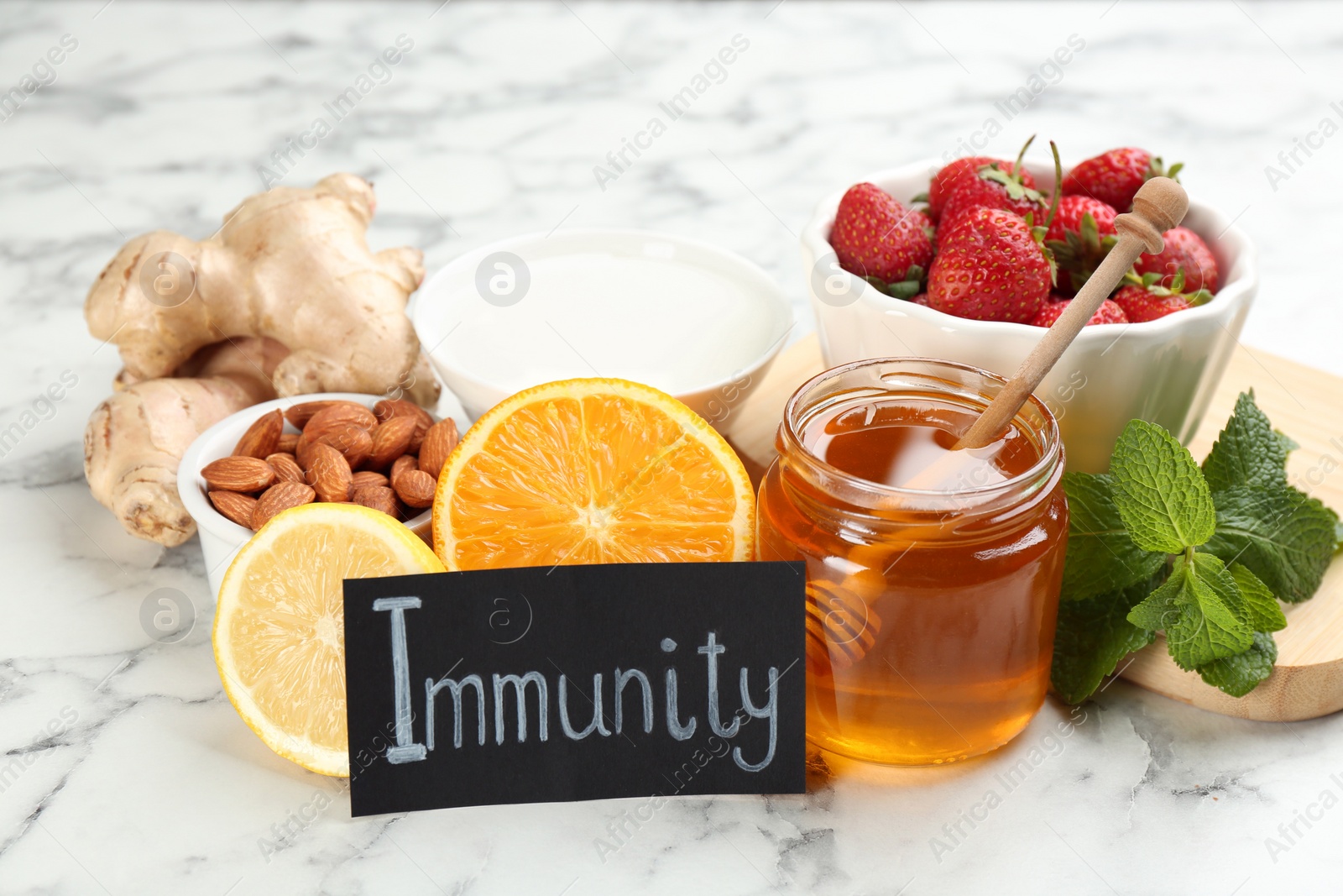 Photo of Card with word Immunity and fresh products on light marble background