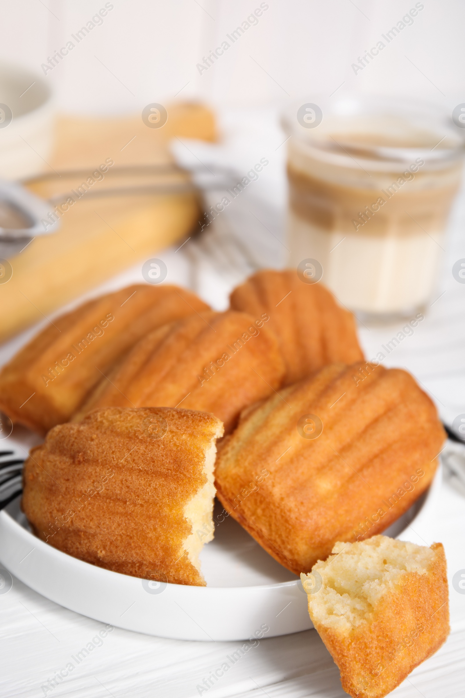 Photo of Delicious madeleine cakes on white wooden table, closeup