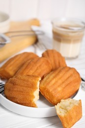 Delicious madeleine cakes on white wooden table, closeup