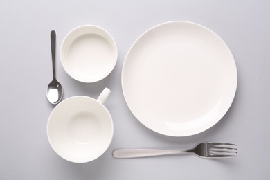 Set of empty clean tableware on grey background, flat lay