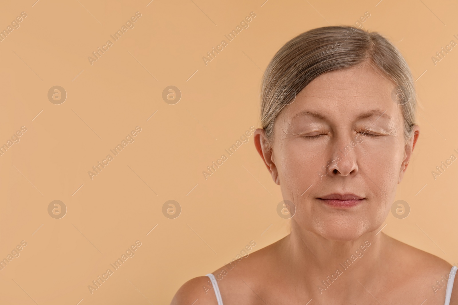 Photo of Woman with closed eyes on beige background, space for text