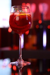 Photo of Glass of delicious refreshing sangria on table against blurred background