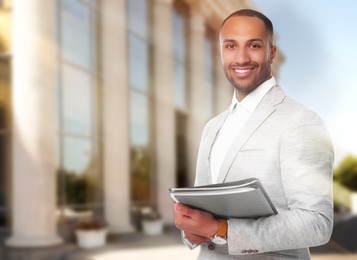 Lawyer, consultant, business owner. Confident man with file folders smiling outdoors, space for text