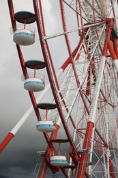 Photo of Beautiful large Ferris wheel against heavy rainy clouds outdoors, closeup